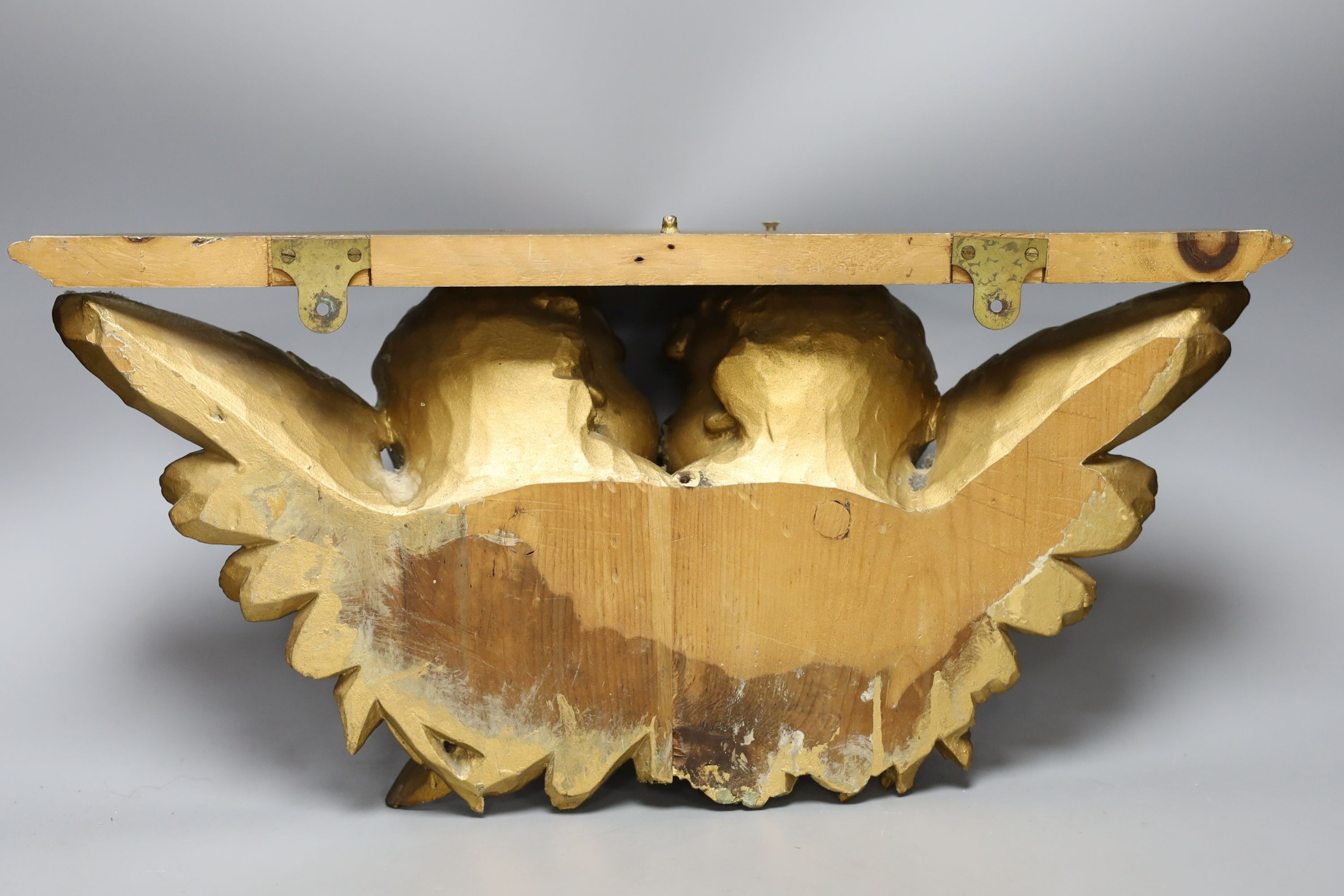 A giltwood cherub bracket 51cm wide